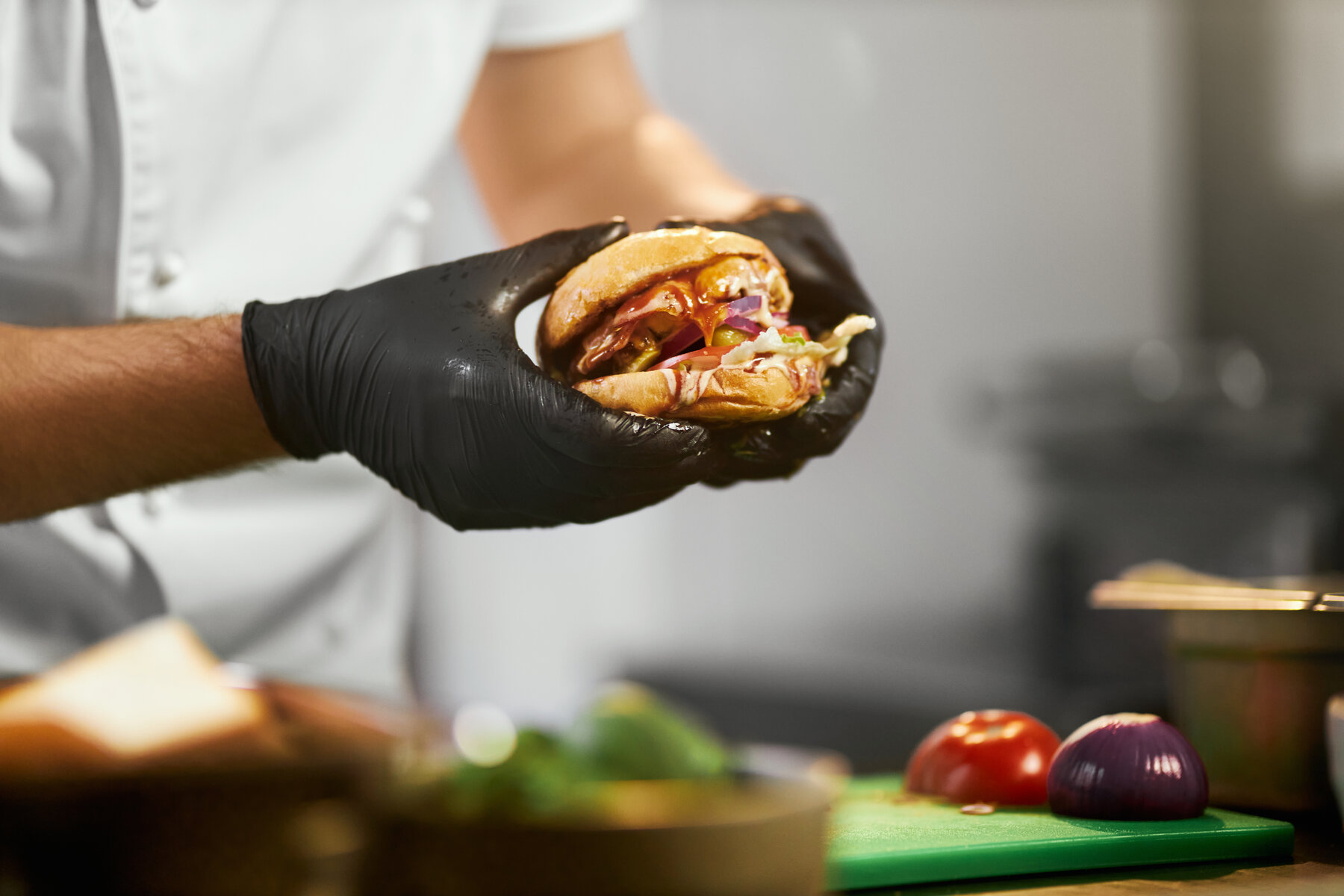 Chef sosteniendo una hamburguesa jugosa recién hecha