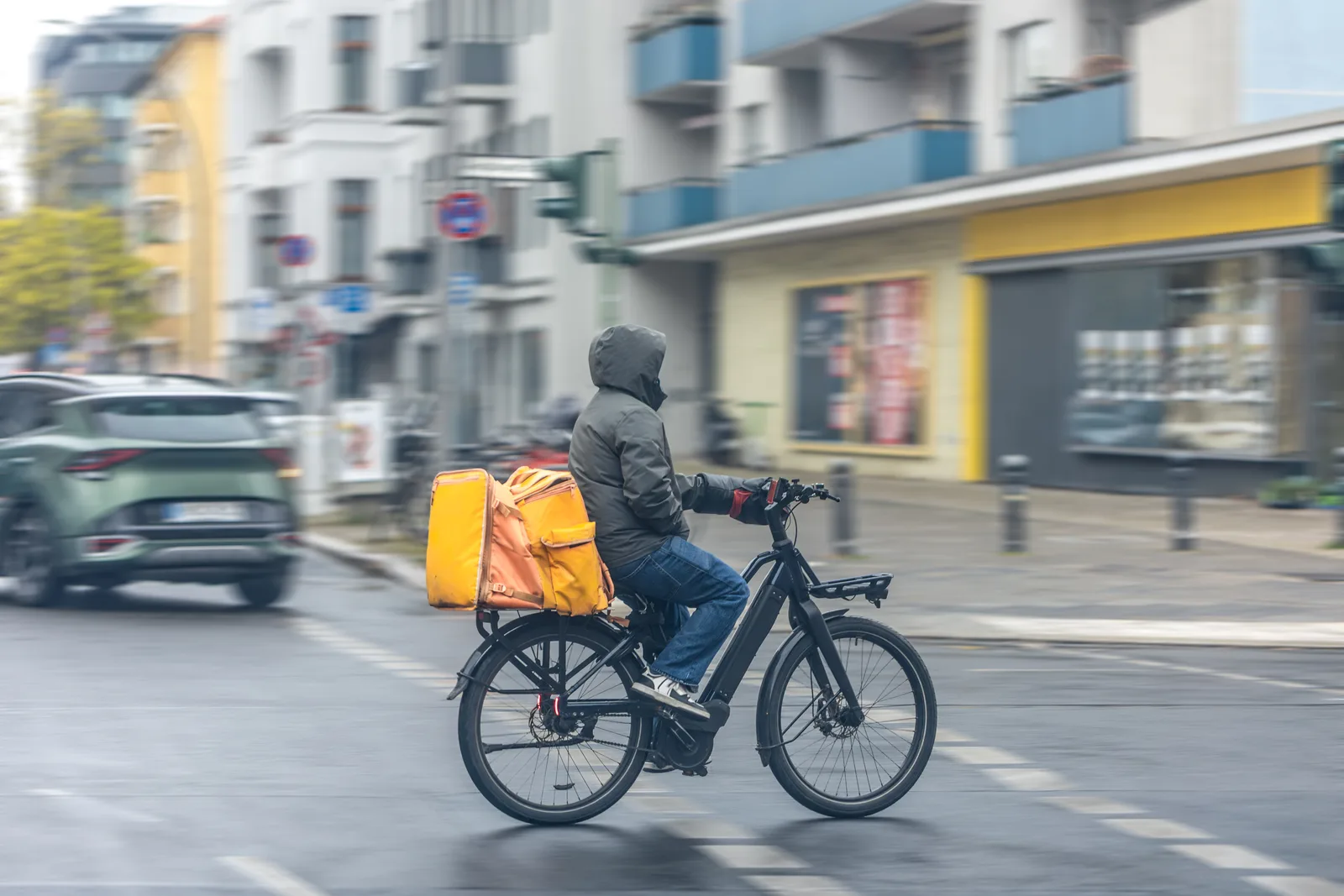 Repartidor en bicicleta llevando un pedido por la ciudad