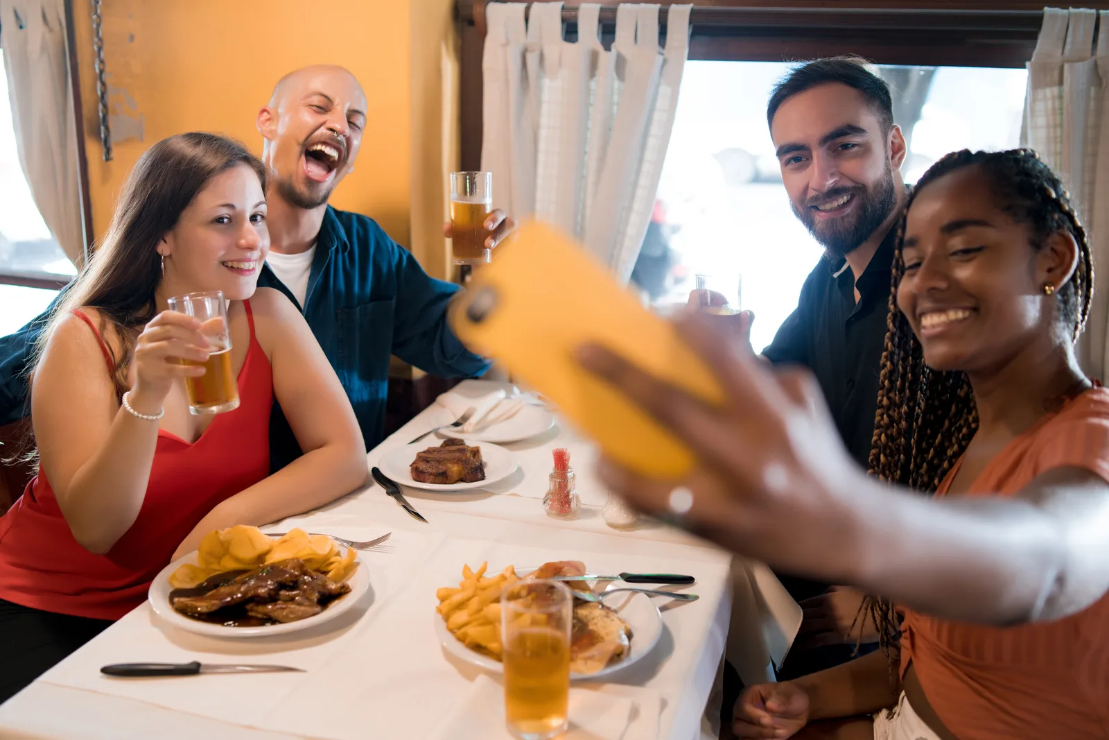 Amigos haciéndose una foto durante una comida en un restaurante