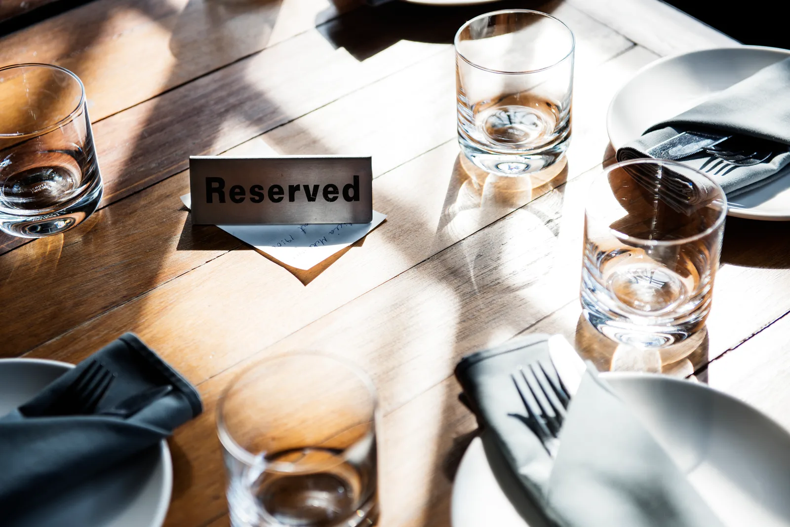 Mesa reservada en un restaurante con cartel de Reservado